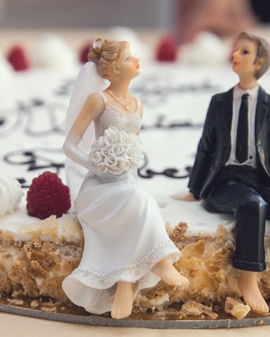Brautpaar-Figuren sitzen auf einer Hochzeitstorte
