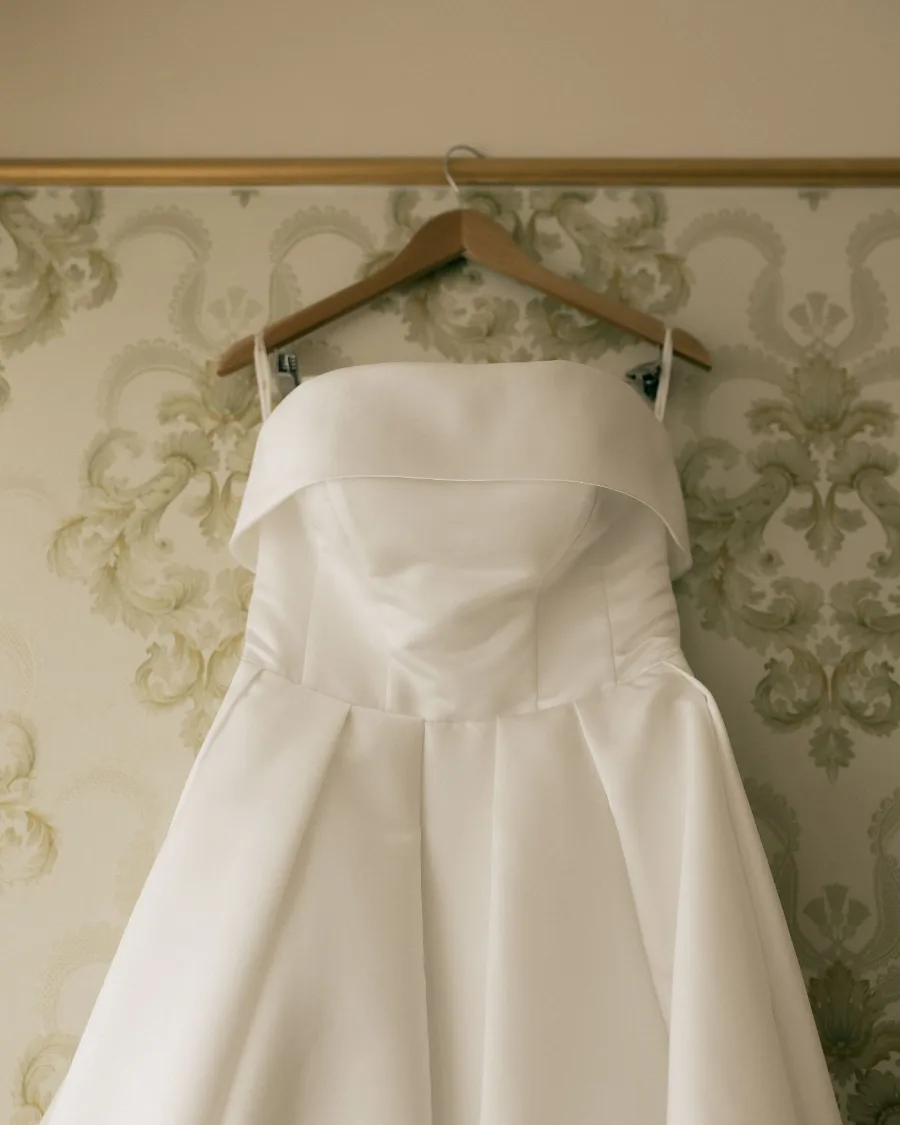 Brautkleid auf einem Bügel vor alter Tapete